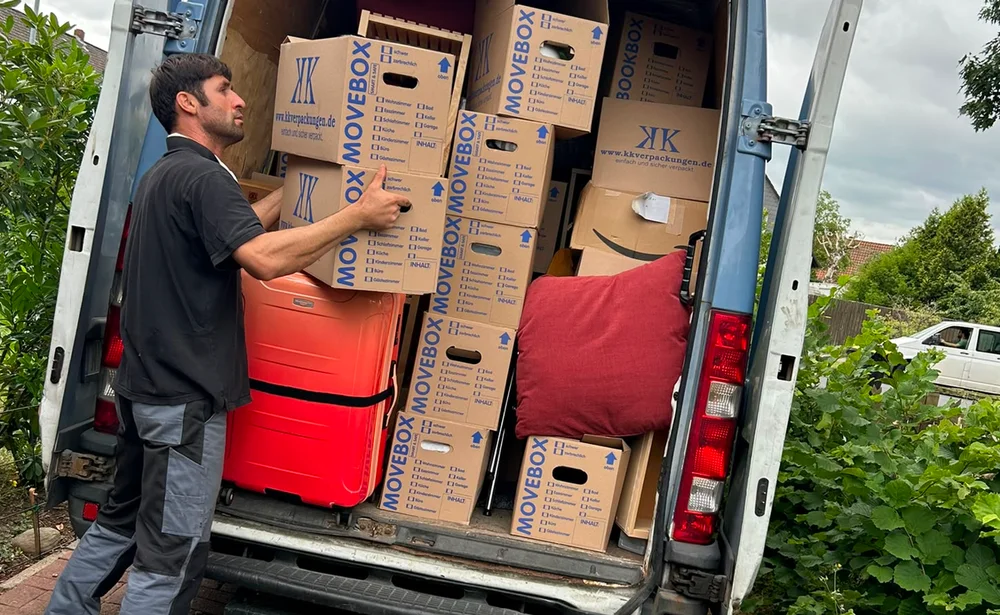 Entrümpelung Nürnberg – Mitarbeiter von LV Transporte lädt beschriftete Umzugskartons in den Transporter