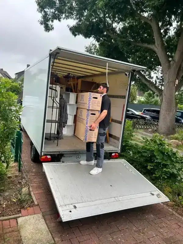 Mitarbeiter von LV Transporte trägt Umzugskartons aus einer Wohnung bei einer Haushaltsauflösung in Nürnberg