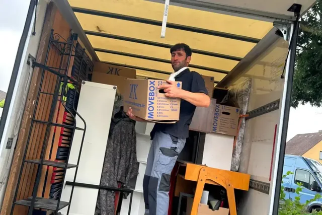 Mitarbeiter sichert Kartons im Möbelkoffer nach einer Hausräumung in Nürnberg-Katzwang